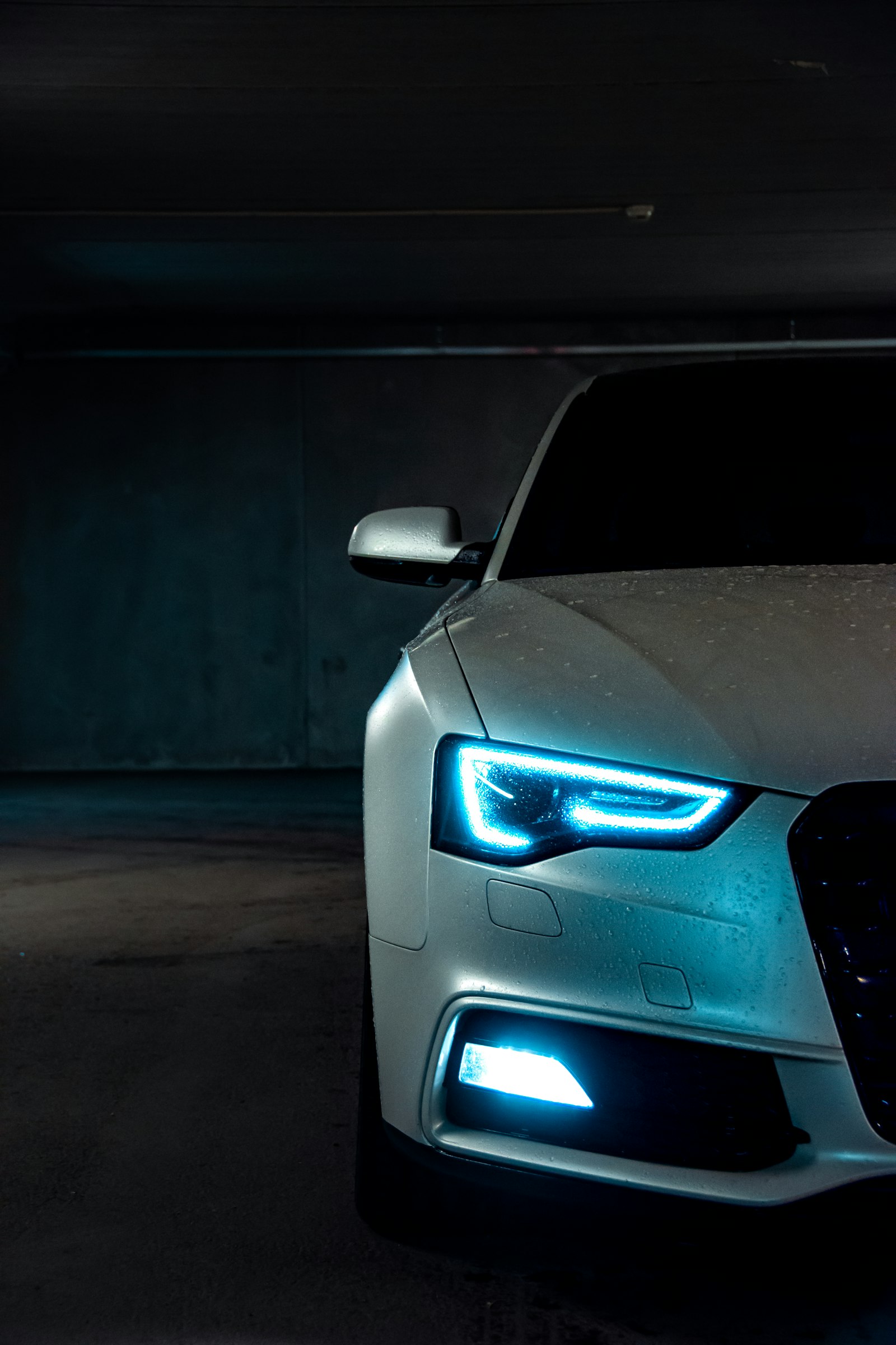 Cars parked in a clean covered garage at night